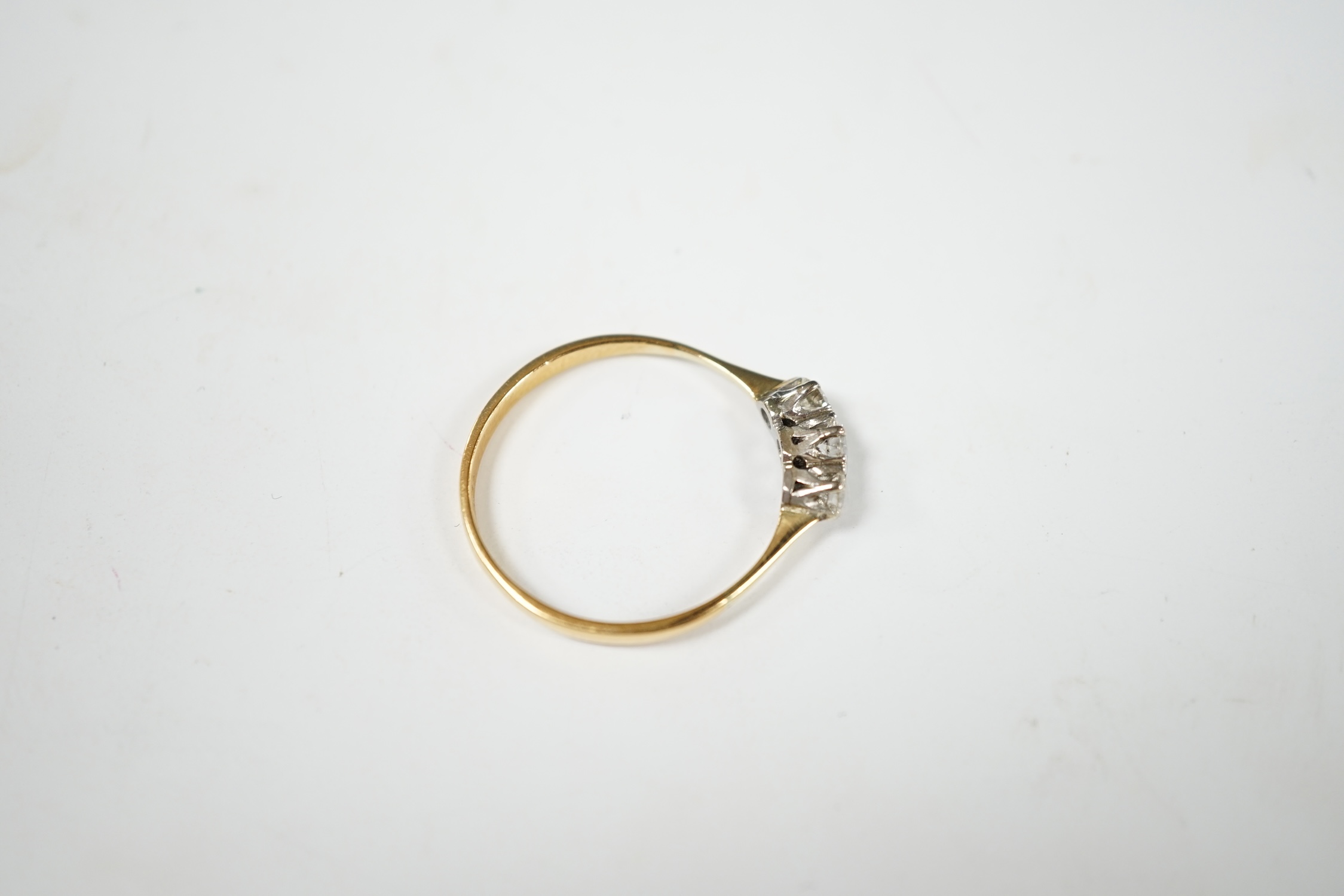 A yellow metal and three stone diamond set ring, size V, gross weight 2.4 grams. Condition - fair